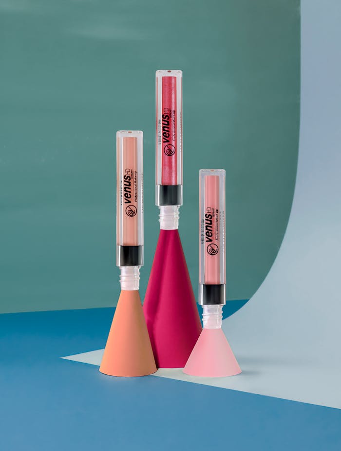 services-header Stylish lip gloss tubes displayed on modern geometric shapes, perfect for beauty and fashion themes.